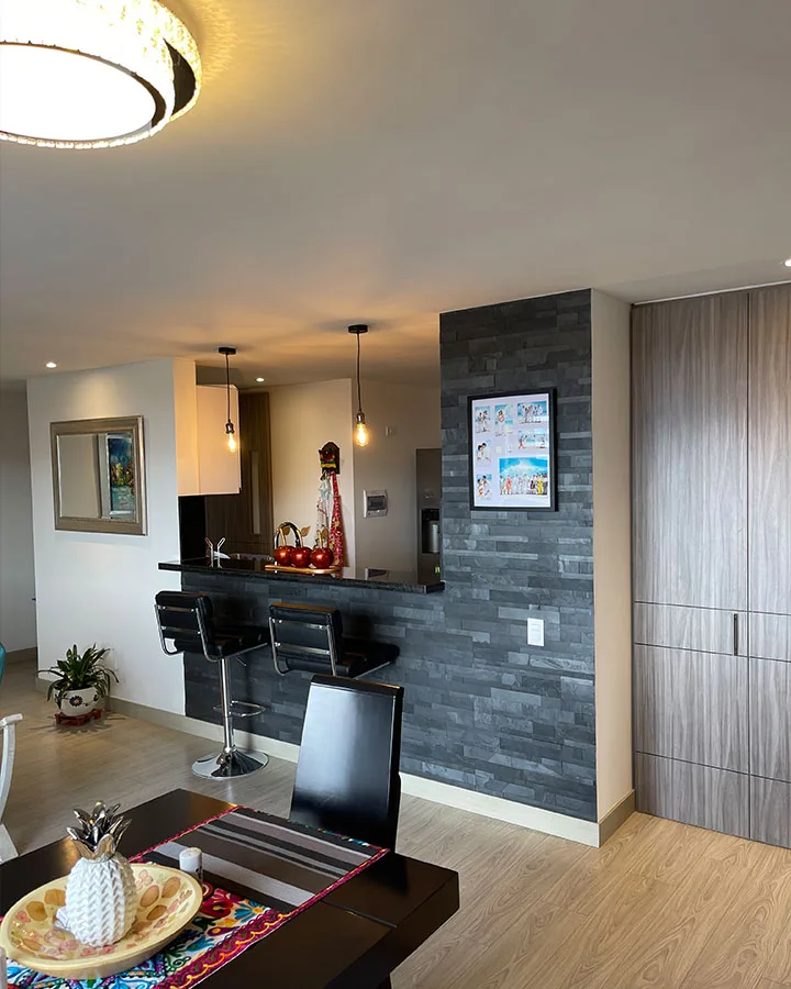 Cocina moderna con muro decorativo revestido en piedra flexible 3D negra autoadhesiva.